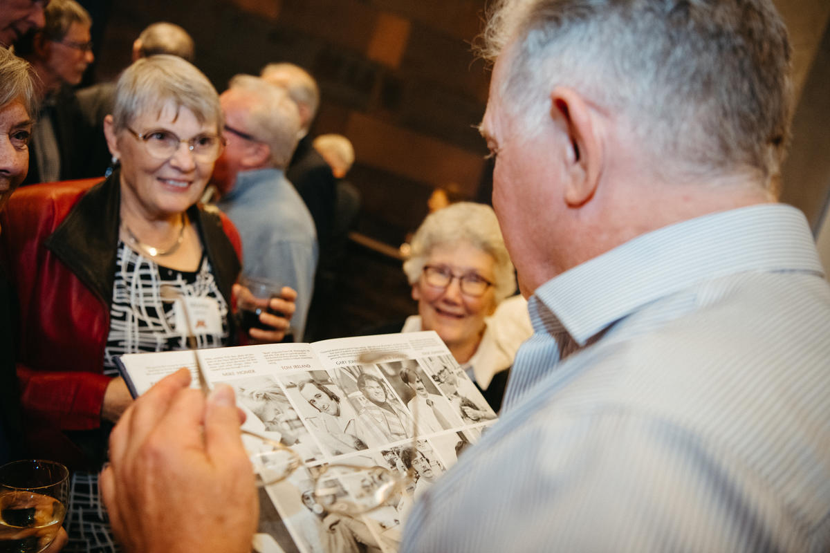 attendees at Alumni Weekend 2023 with a cartoon graphic novel book