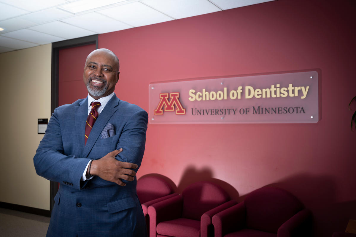 Dean Keith A Mays DDS MS PHD in front of a logo of the School of Dentistry